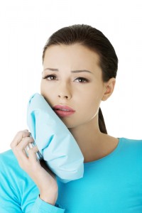 woman with a ice pack up to her jaw, due to pain