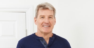 Mature man smiling, showing off his natural looking implant dentures