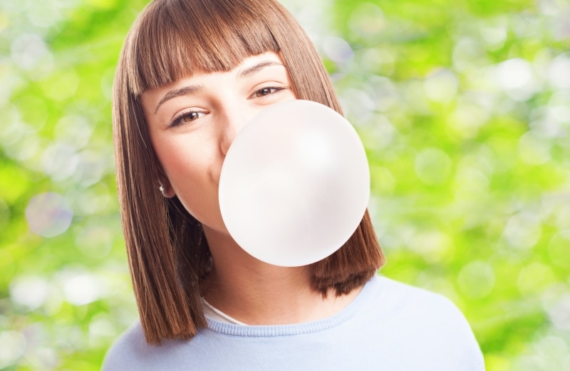 Little girl blowing a big gum bubble