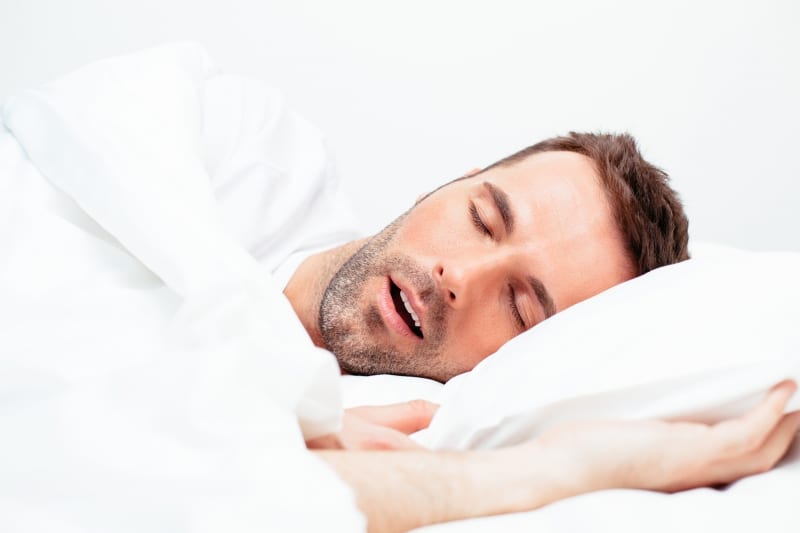man laying on his side, snoring