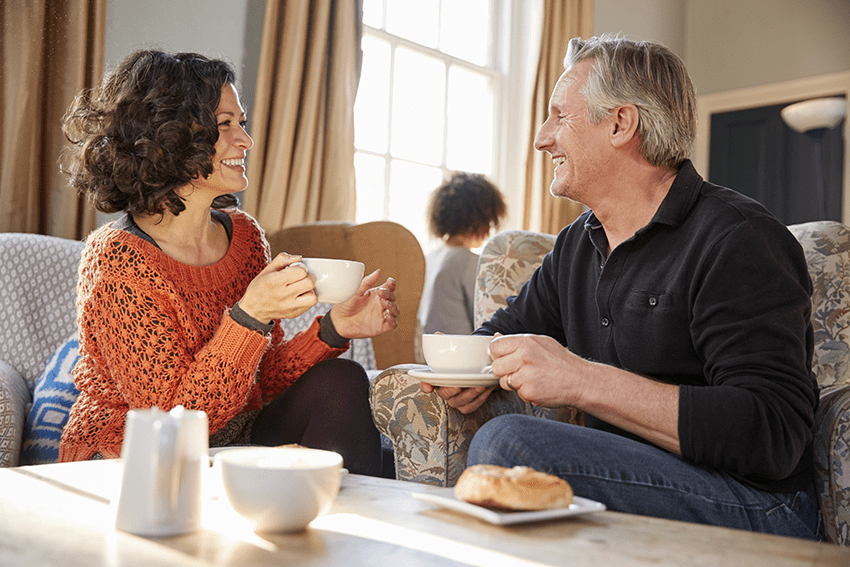 Middle Aged Couple Sitting Around Table In Coffee Shop
