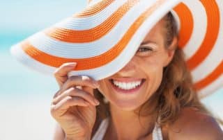 woman wearing a sun hat and smiling with teeth
